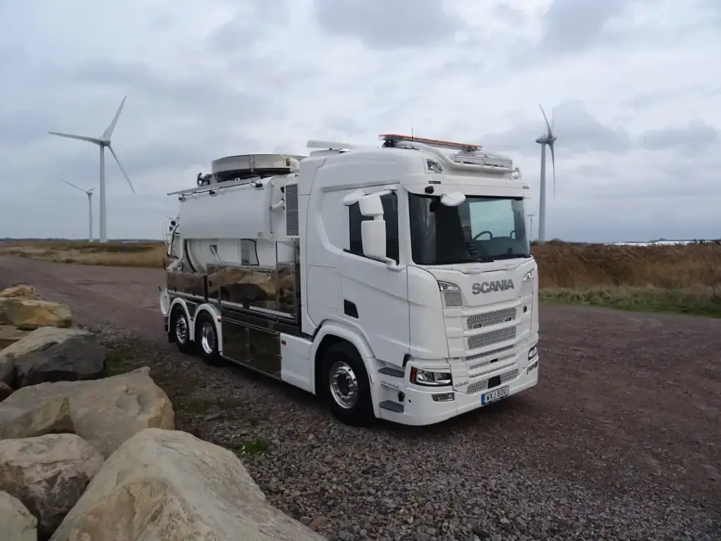 Miljøvennlig energibuss med vindkraft i bakgrunn, klimavennlig transportløsning.